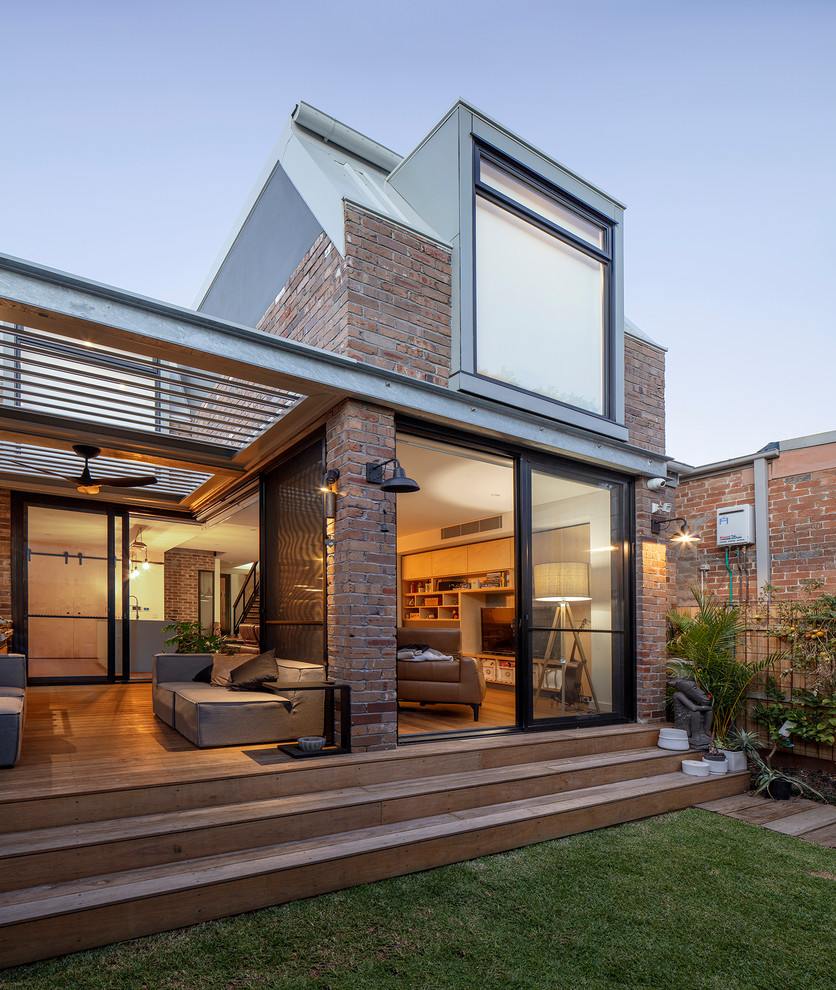 This is an example of a red contemporary two floor brick detached house in Sydney with a flat roof.