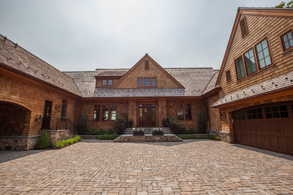 Diseño de fachada de casa marrón marinera grande de dos plantas con revestimiento de madera, tejado a dos aguas y tejado de teja de madera