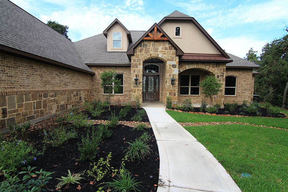 Großes, Zweistöckiges Klassisches Einfamilienhaus mit Steinfassade, brauner Fassadenfarbe, Schindeldach, grauem Dach und Halbwalmdach in Houston