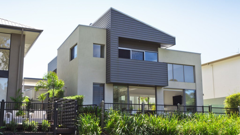 Réalisation d'une grande façade de maison multicolore minimaliste à un étage avec un revêtement mixte, un toit plat et un toit végétal.