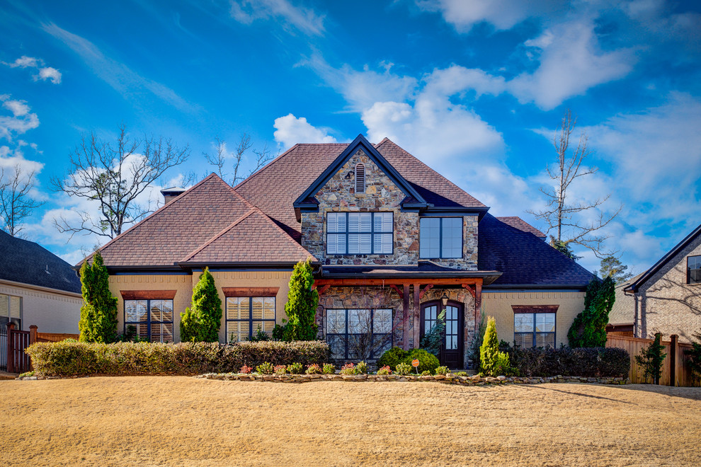 Ejemplo de fachada de casa beige clásica extra grande de dos plantas con revestimientos combinados, tejado a dos aguas y tejado de teja de barro