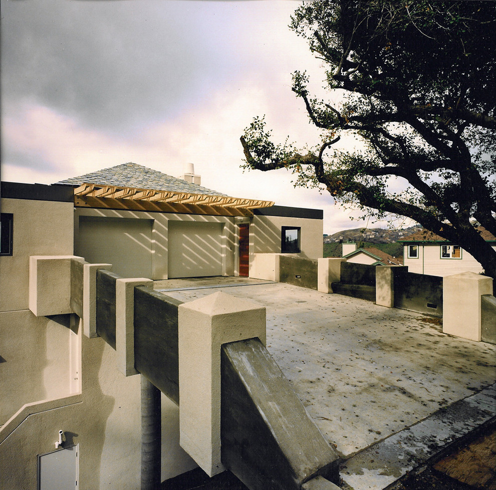 Inspiration pour une petite façade de maison blanche design en stuc à deux étages et plus avec un toit à quatre pans et un toit en tuile.