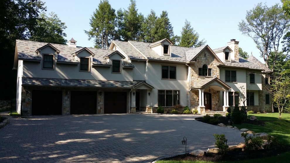 Inspiration for a large timeless beige two-story mixed siding gable roof remodel in New York