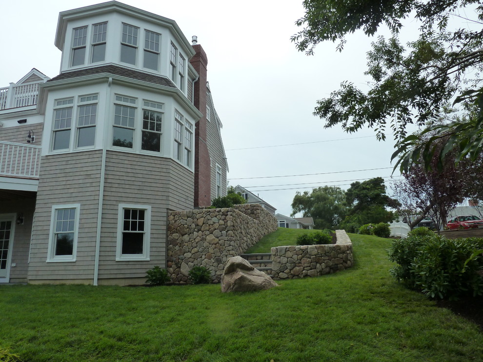 Photo of a medium sized and gey beach style two floor house exterior in Boston with wood cladding.