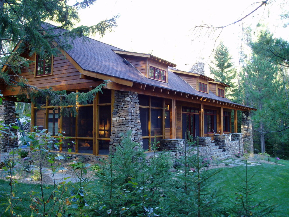 Réalisation d'une façade de maison marron chalet en bois de taille moyenne et à un étage.