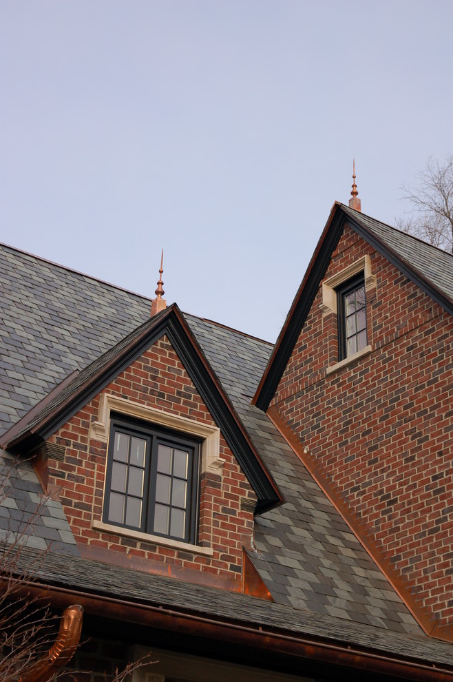 Aménagement d'une grande façade de maison rouge classique en brique à deux étages et plus avec un toit en shingle.