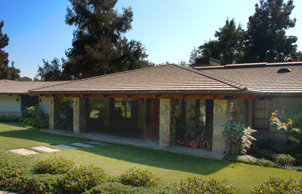 Diseño de fachada de casa gris de estilo zen grande de una planta con revestimiento de piedra, tejado a dos aguas y tejado de teja de madera