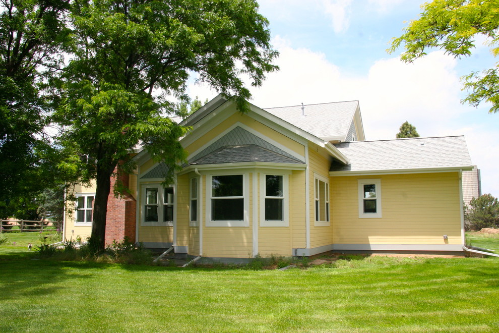 Mittelgroßes, Zweistöckiges Country Haus mit Faserzement-Fassade und gelber Fassadenfarbe in Denver