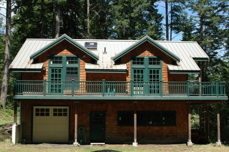 Идея дизайна: маленький, двухэтажный, деревянный, коричневый частный загородный дом в стиле рустика с двускатной крышей и металлической крышей для на участке и в саду