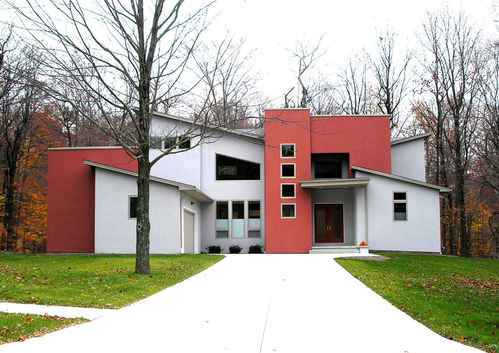 Exemple d'une grande façade de maison rouge tendance à deux étages et plus avec un toit plat.