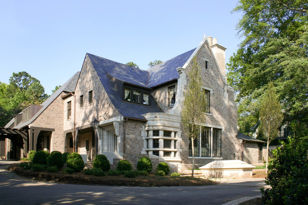Ejemplo de fachada de casa beige tradicional grande de dos plantas con revestimientos combinados, tejado a dos aguas y tejado de teja de madera