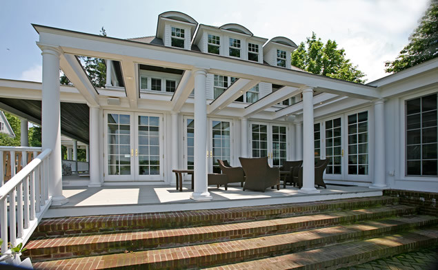 Diseño de fachada de casa blanca costera grande de dos plantas con revestimiento de aglomerado de cemento, tejado a cuatro aguas y tejado de teja de madera
