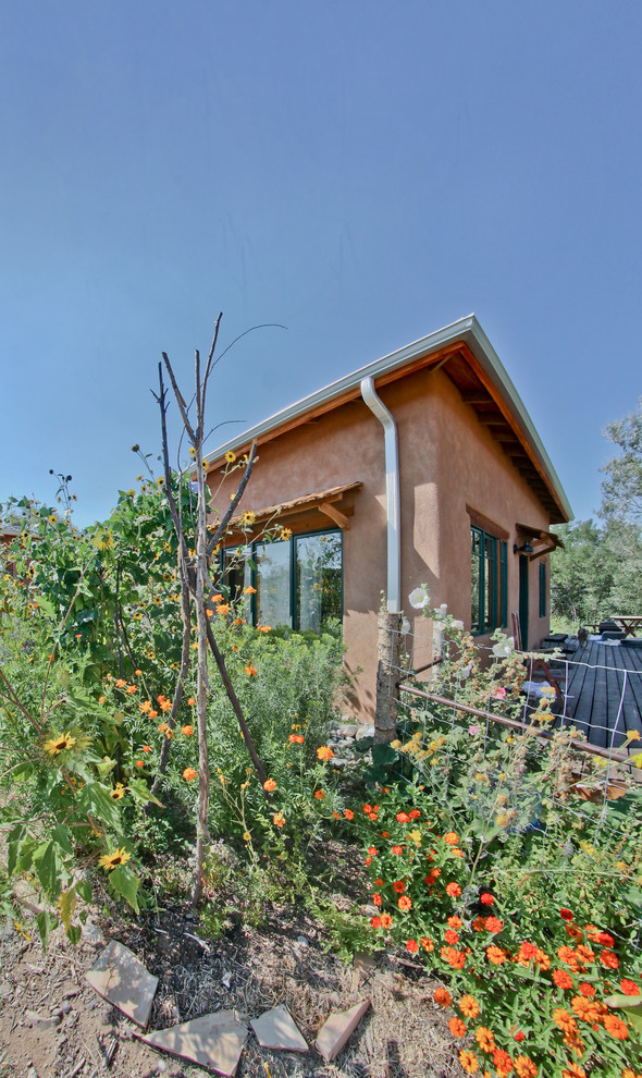 Diseño de fachada de casa marrón de estilo americano de tamaño medio de una planta con revestimiento de estuco, tejado a cuatro aguas y tejado de metal