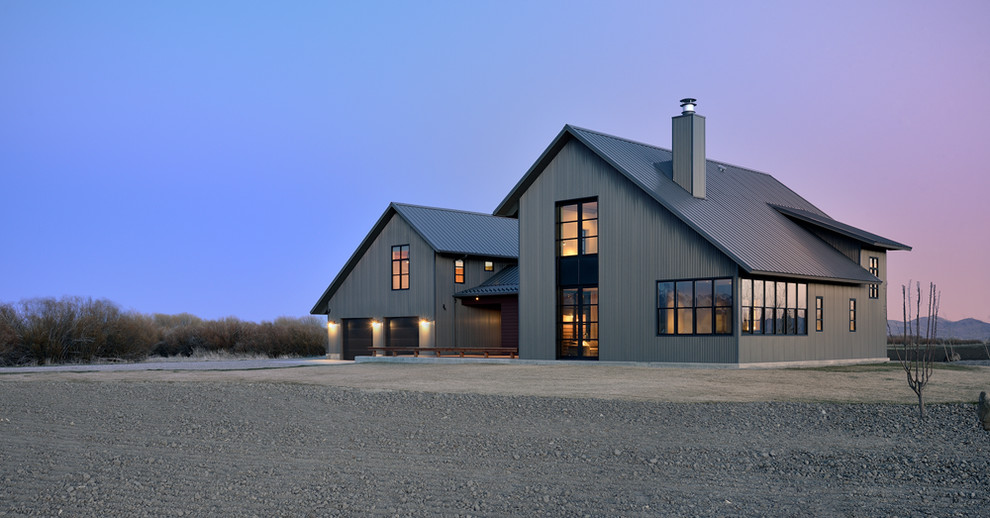 Идея дизайна: большой, двухэтажный, серый дом в стиле кантри с облицовкой из металла и двускатной крышей