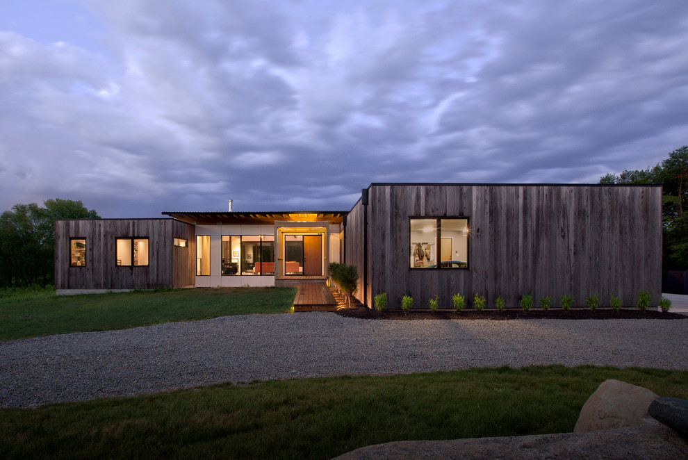 Ejemplo de fachada de casa gris moderna de tamaño medio de dos plantas con revestimiento de madera, tejado plano y tejado de metal