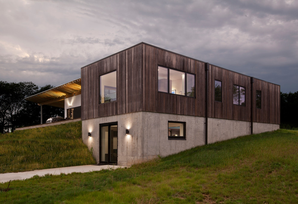 Пример оригинального дизайна: двухэтажный, деревянный, коричневый частный загородный дом среднего размера в стиле модернизм с плоской крышей и металлической крышей