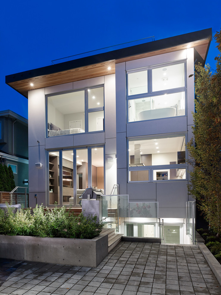 Ejemplo de fachada de casa gris moderna de tamaño medio de dos plantas con revestimiento de aglomerado de cemento, tejado plano y tejado de teja de barro