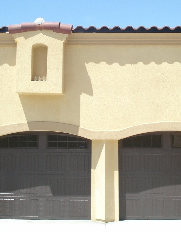 Inspiration pour une grande façade de maison jaune méditerranéenne en stuc à un étage avec un toit à quatre pans, un toit en tuile et un toit rouge.