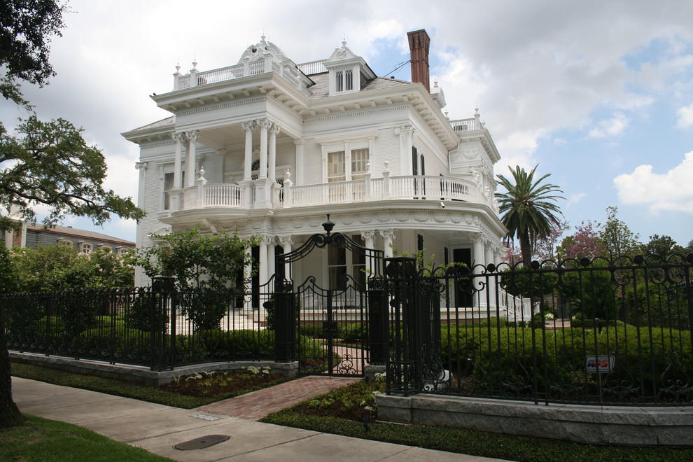 Large victorian house exterior in New Orleans with three floors and wood cladding.