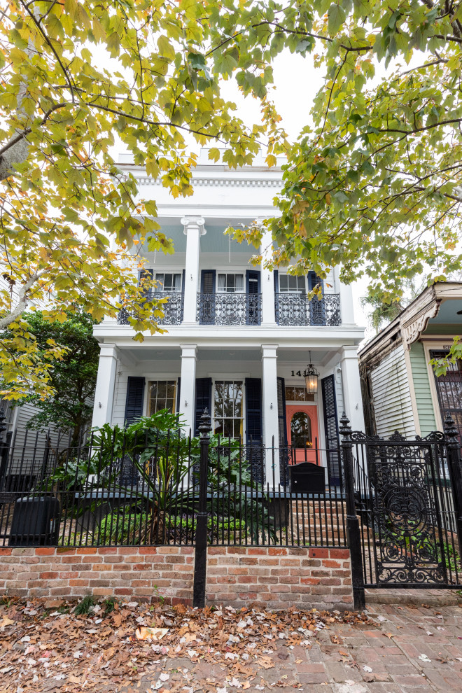 Großes, Zweistöckiges Stilmix Einfamilienhaus mit Vinylfassade, weißer Fassadenfarbe, Flachdach und Misch-Dachdeckung in New Orleans