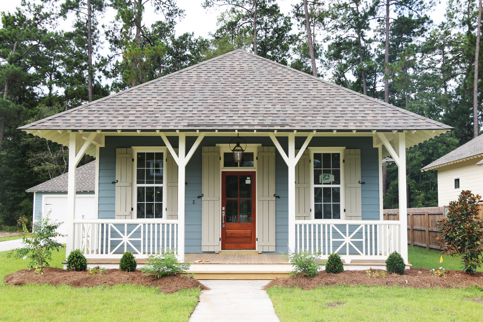 Exempel på ett mellanstort klassiskt blått hus, med allt i ett plan, fiberplattor i betong och valmat tak