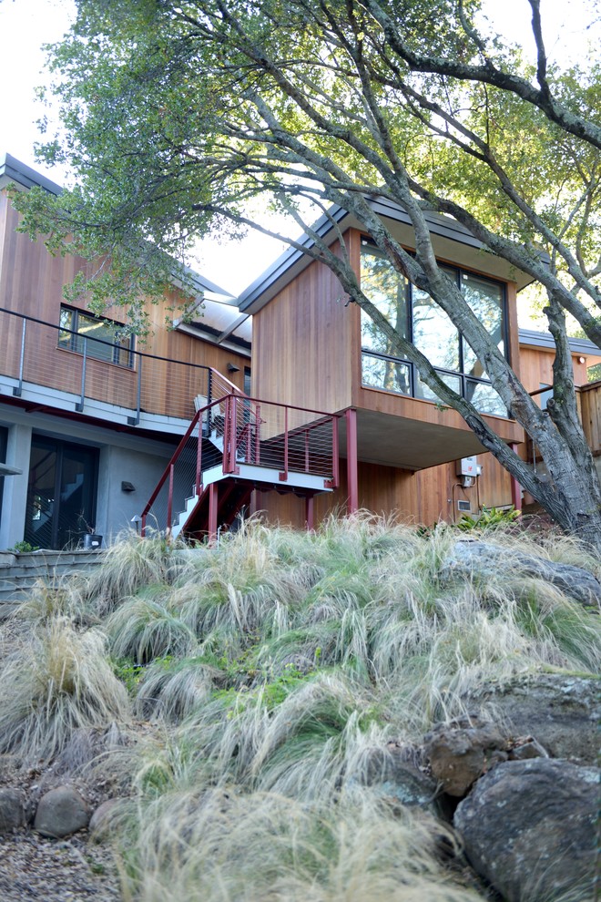 Example of a large trendy brown two-story wood exterior home design in San Francisco with a metal roof and a gray roof