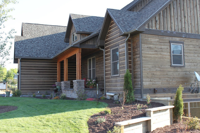 Idée de décoration pour une grande façade de maison marron chalet en bois à un étage avec un toit à deux pans et un toit en shingle.