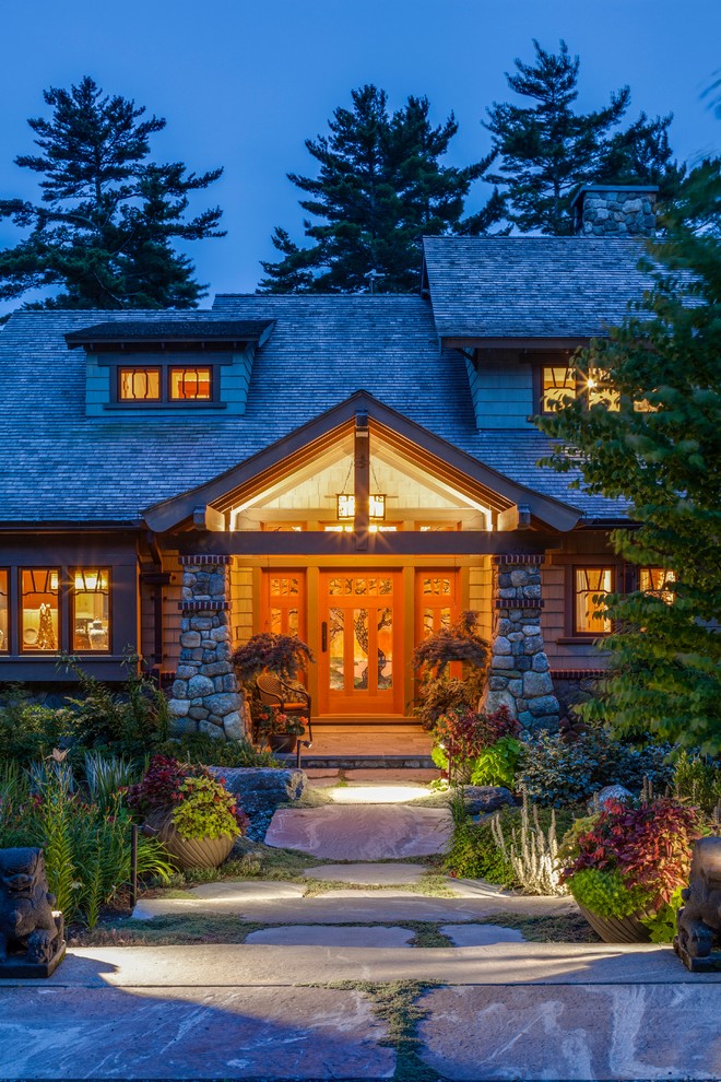 Cette image montre une façade de maison verte craftsman en bois de taille moyenne et à un étage avec un toit en shingle et un toit à deux pans.