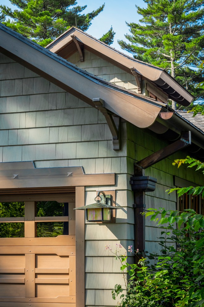 Foto della villa verde american style a due piani di medie dimensioni con rivestimento in legno, tetto a capanna, copertura a scandole e abbinamento di colori