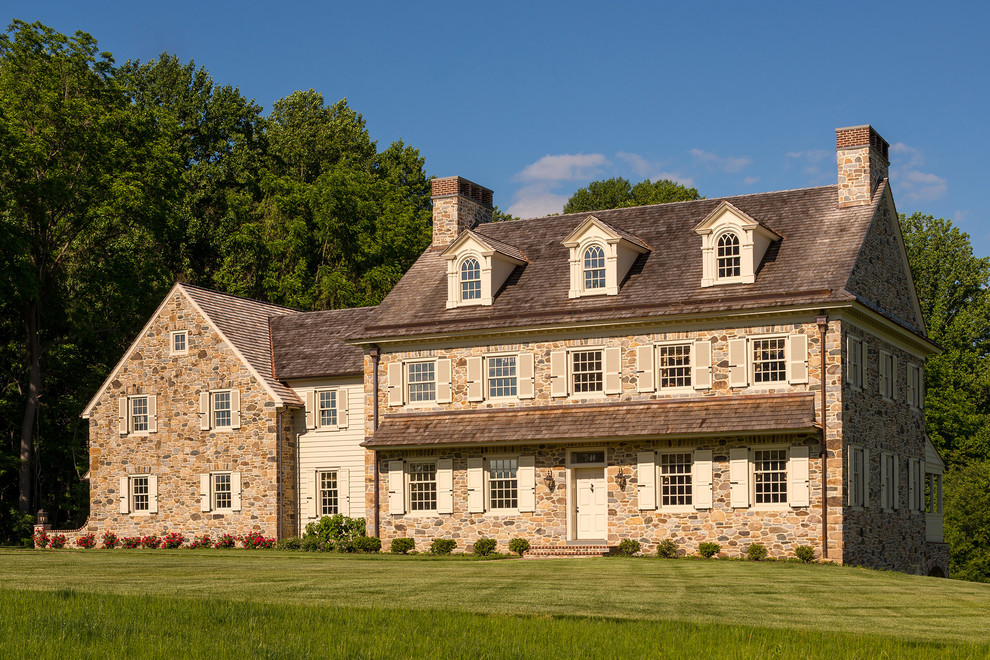 Cette photo montre une façade de maison beige nature en pierre à un étage avec un toit à deux pans.
