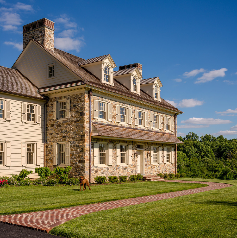 Zweistöckiges Country Haus mit Steinfassade, beiger Fassadenfarbe und Satteldach in Philadelphia