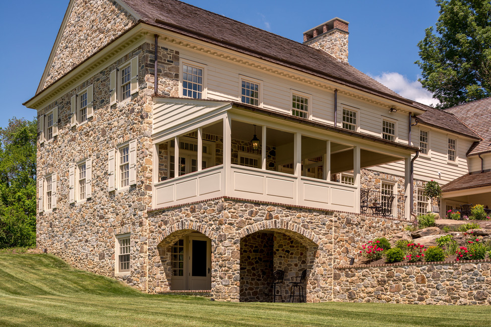 Idee per la facciata di una casa beige country a due piani con rivestimento in pietra e tetto a capanna
