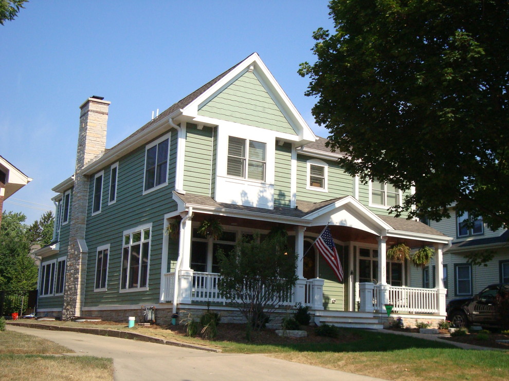 Esempio della facciata di una casa grande verde classica a due piani con rivestimento in legno