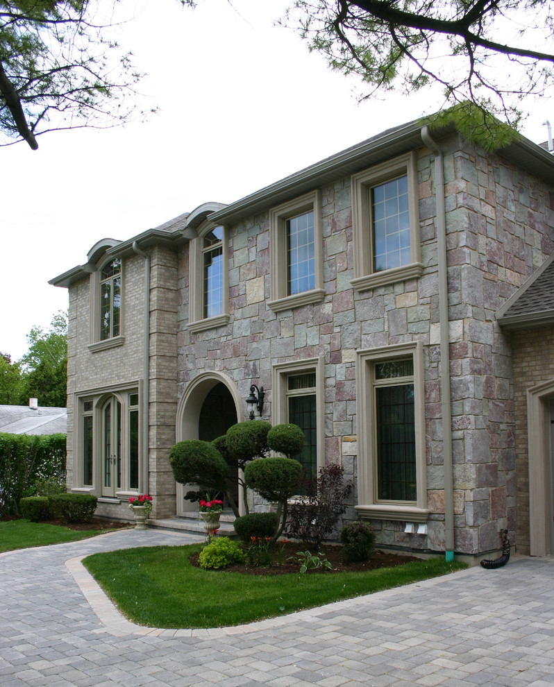 Esempio della facciata di una casa beige classica a due piani di medie dimensioni con rivestimento in pietra e tetto a padiglione