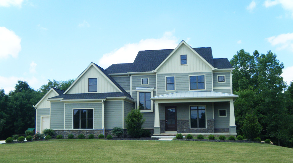 Example of a mid-sized cottage multicolored three-story mixed siding exterior home design in Columbus with a shingle roof