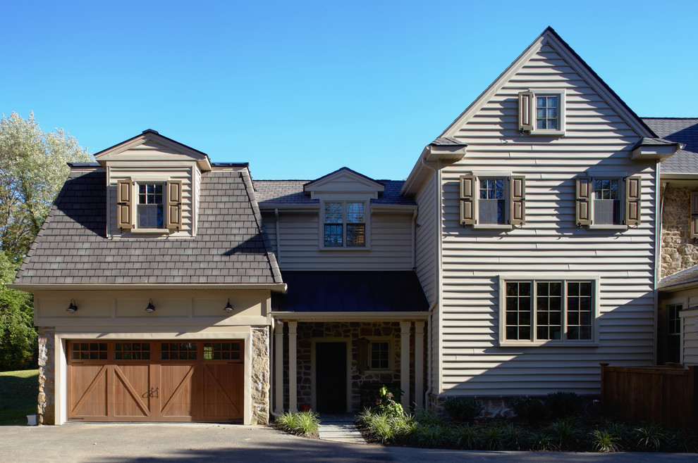 Inspiration pour une grande façade de maison beige traditionnelle à un étage avec un revêtement mixte.