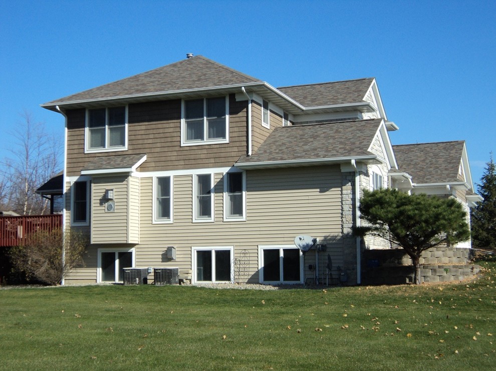 Example of a classic gray two-story mixed siding house exterior design in Cedar Rapids with a hip roof and a shingle roof