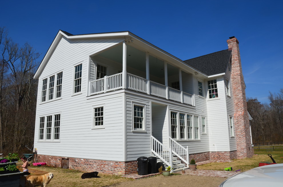 This is an example of a medium sized and white country two floor house exterior in Baltimore with concrete fibreboard cladding.