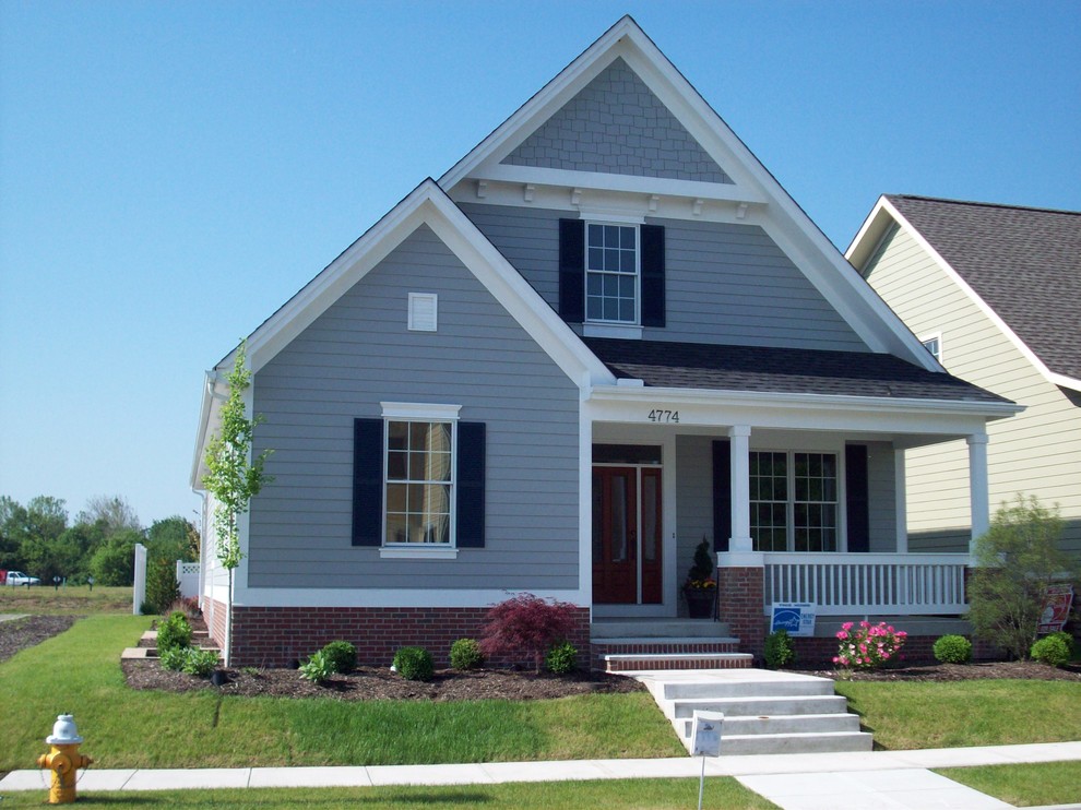 Cette photo montre une façade de maison bleue chic en panneau de béton fibré de taille moyenne et de plain-pied.