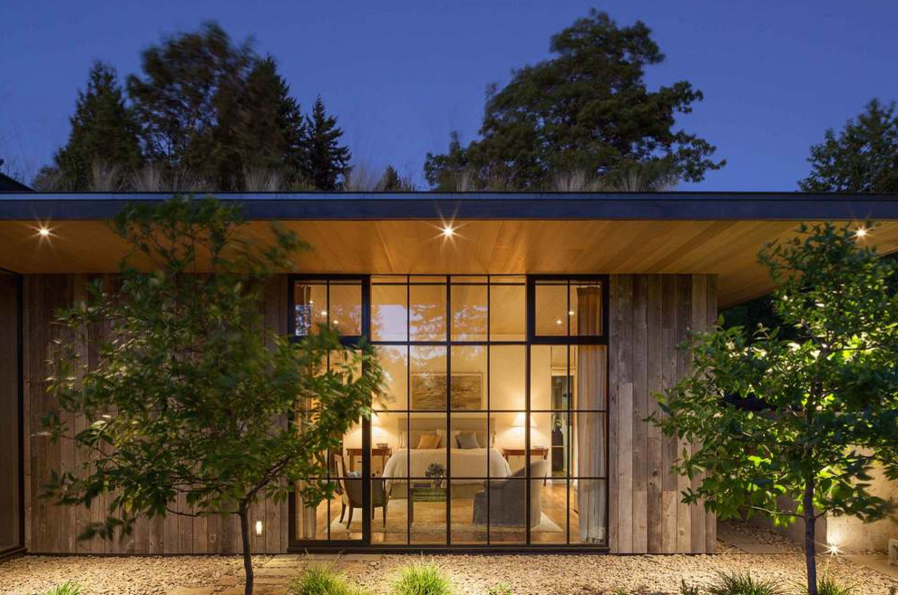 Idee per la villa beige country a un piano con rivestimento in legno, tetto piano e copertura verde