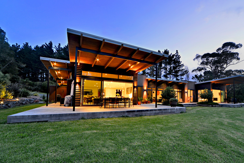 Idée de décoration pour une grande façade de maison marron design en bois de plain-pied avec un toit plat et un toit en métal.