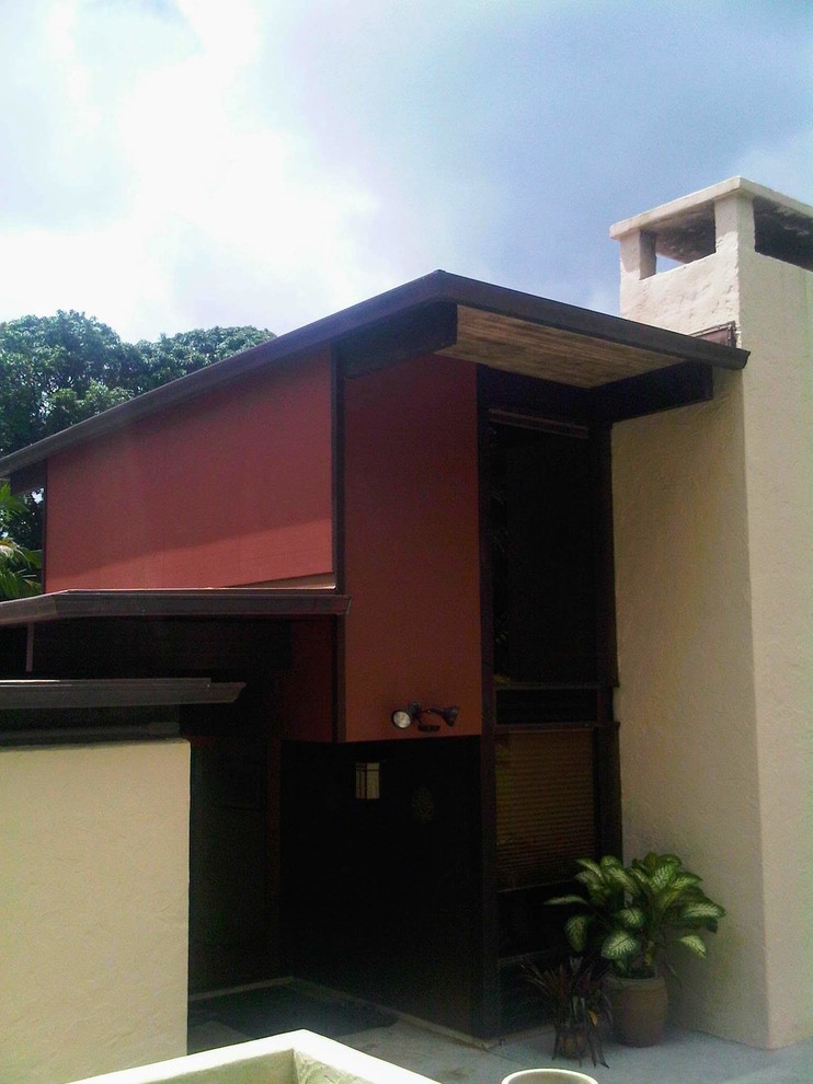 Aménagement d'une grande façade de maison beige asiatique en stuc à un étage avec un toit plat et un toit en métal.