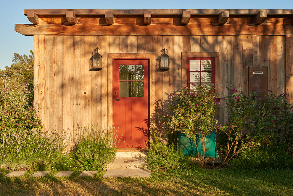 Ispirazione per la facciata di una casa marrone rustica a due piani con rivestimento in legno e tetto a capanna