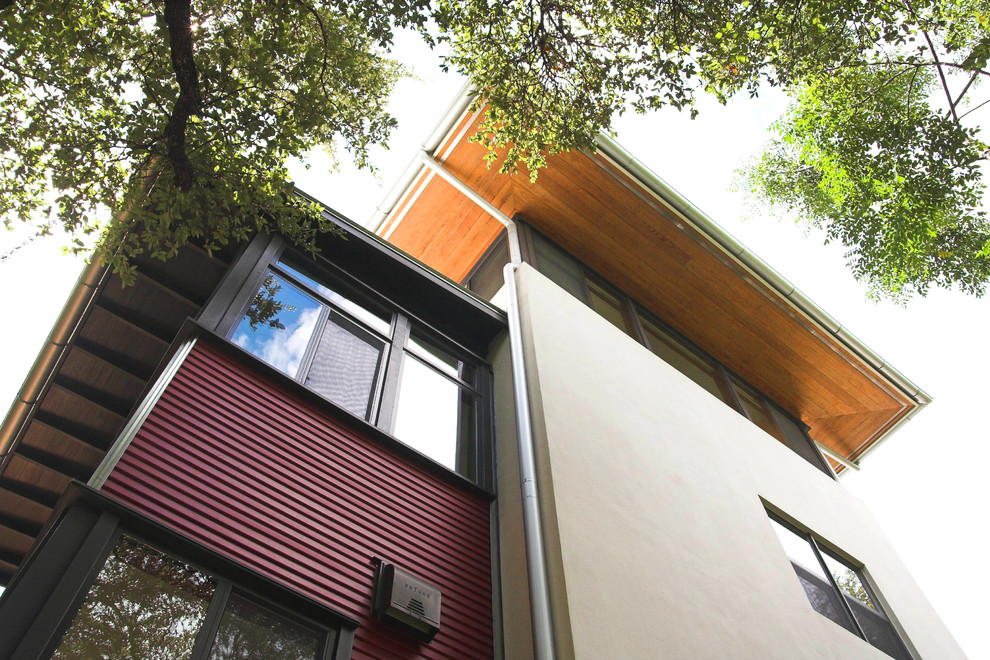 Cette photo montre une grande façade de maison beige moderne à deux étages et plus avec un revêtement mixte et un toit plat.