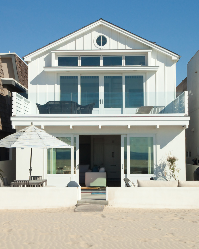 Small beach style white two-story vinyl gable roof photo in Orange County