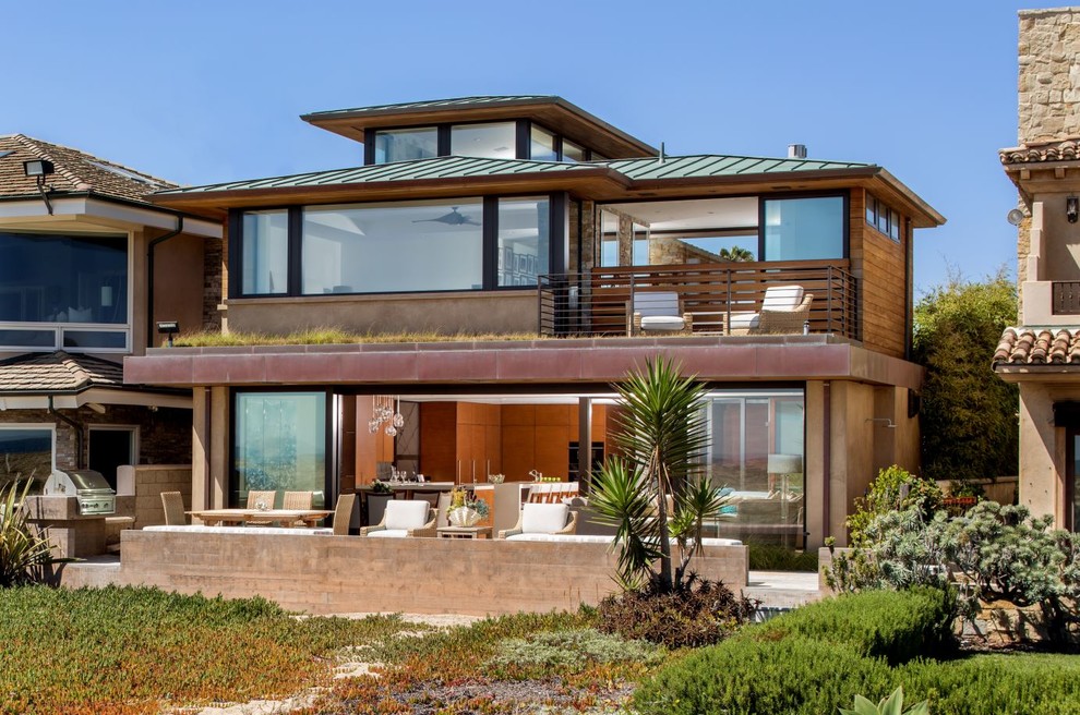 На фото: трехэтажный, коричневый частный загородный дом среднего размера в современном стиле с комбинированной облицовкой, вальмовой крышей и зеленой крышей