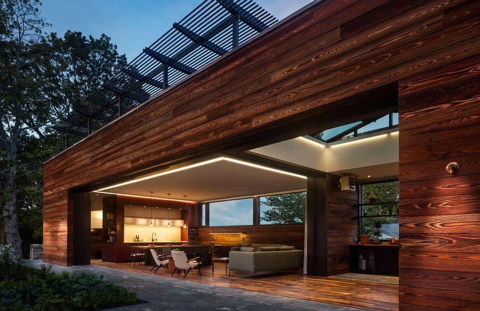 Cette image montre une grande façade de maison marron design en bois de plain-pied avec un toit plat.