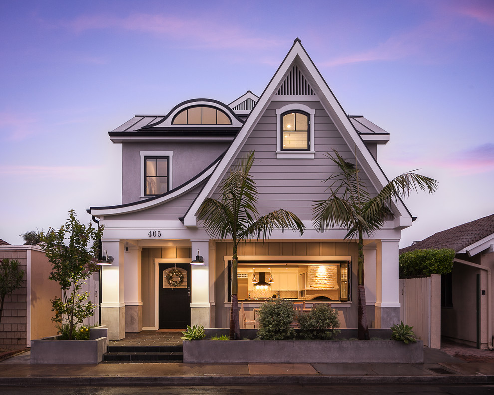Diseño de fachada de casa gris marinera de dos plantas con revestimiento de madera y tejado de metal