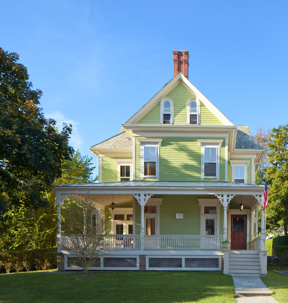 Пример оригинального дизайна: большой, трехэтажный, зеленый дом в викторианском стиле с двускатной крышей