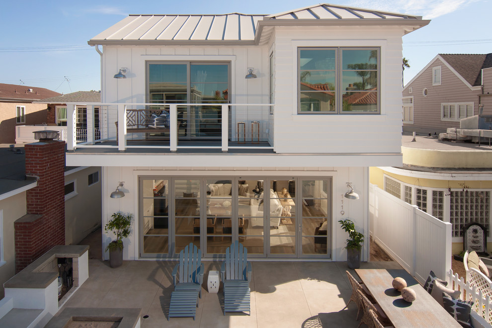 На фото: двухэтажный, белый дом среднего размера в морском стиле с комбинированной облицовкой с